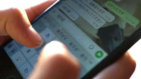 Woman's hand writing a message  “Thank you” in Japanese on her cellphone Stock Footage 298989668