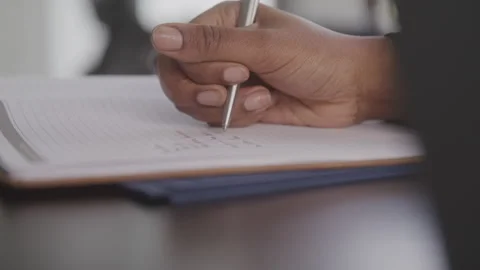 Woman's Hand Writing in Notebook on Desk Stockbeeldmateriaal 208778543