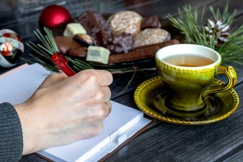 A woman's hand writing in a notebook a plan for the new year in a cozy sett.. Stock Photos