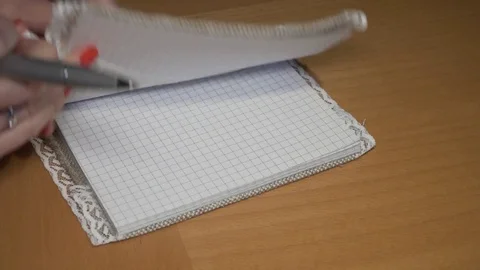 Woman's hand writing Wish list in a handmade notebook (scrapbook) Stock Footage 84238432