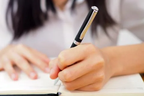 The woman's hand is written using the left hand. Foto stock