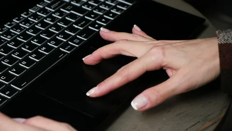 Woman's hand zooming in on a black laptop touch-pad Stock Footage
