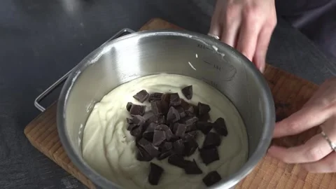 A woman's hands add chocolate chips to the dough. Stock Footage 341658814