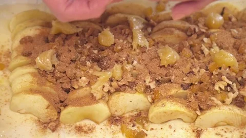 Woman's hands adding cinnamon to the apples with nuts on the strudel Stock Footage 74463943