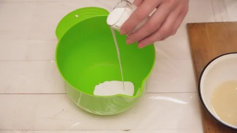 Woman's hands adding milk to the bowl Stock Footage 74468354