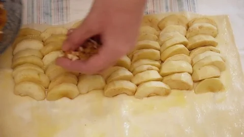 Woman's hands adding nuts to the apples on the dough Stock Footage 74463628