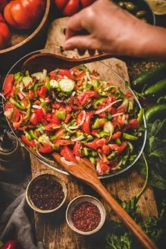 Womans hands adding spices to Turkish Chopard Salad with vegetables Stock Photos