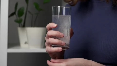 Woman's hands applying effervescent tablet into a drinking glass Stock Footage 260514311