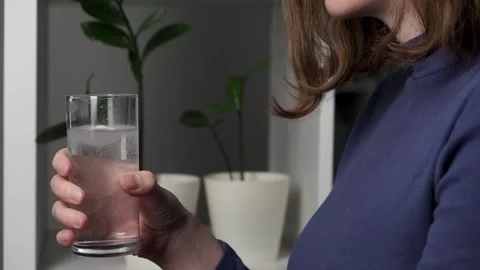 Woman's hands applying effervescent tablet into a drinking glass Stock Footage 264186948