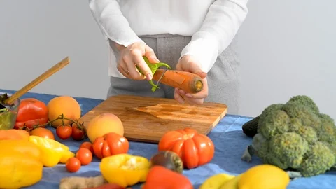 Woman's hands are peeling carrots using food peeler. Stock Footage 115914545