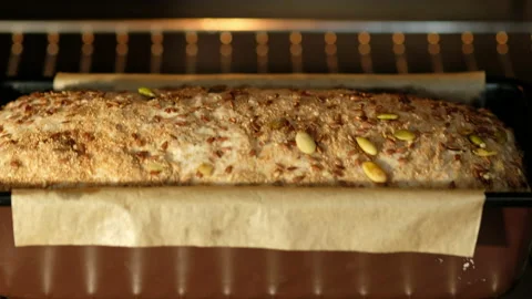 Woman's hands are putting bread in the oven in the mold. Whole grain bread from Stock Footage 131318222