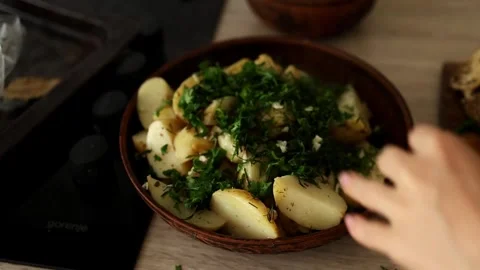 A woman’s hands are serving freshly boiled potatoes with herbs and meat Stock Footage 312195415
