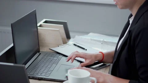 A woman's hands are typing on her laptop. A young woman works in a bright office Stock Footage 206038331