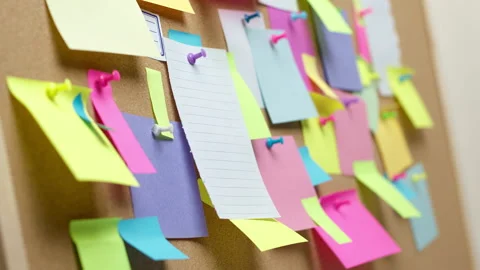 Woman's hands attaching a note to the stickers on the cork board Stock Footage 232260194