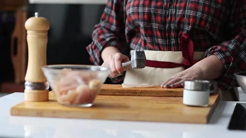 Woman's hands banging raw chicken fillet with a small iron hammer. slow motion Stock Footage 231794435