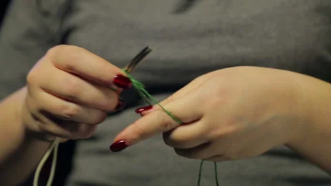 Woman's hands on a black background dials on the spokes of a loop of green Stock Footage 103951005