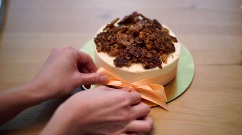 Woman's hands is bow ties on the cake Stock Footage 56480059