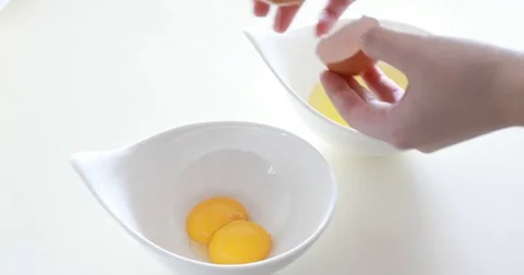 Woman's hands breaking egg and separating yolk from white Video stock 81894090