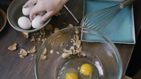 Woman's hands breaking an egg into a bowl Stock Footage 75759542
