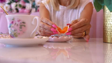 Woman's hands breaking open a Portuguese sweets at a pink cafe table Stock Footage 341422492