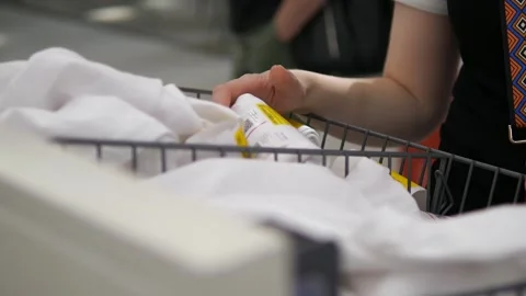 A womans hands browse through a bin in a clothing store, selecting a white Stock Footage 318283053