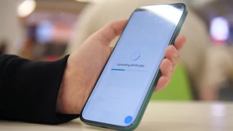 A womans hands in a cafe setting successfully upload a photo file to cloud Stock Footage 318661392