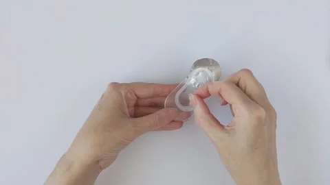 Woman's hands carefully remove a new contact lens from a plastic blister pack Stock Footage 330748413