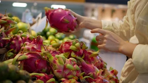 Womans hands choosing fresh raw dragon fruit in the supermarket Stock Footage 81648227