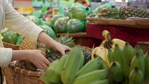 Woman's hands choosing pineapple during shopping at supermarket Stock Footage 81645510