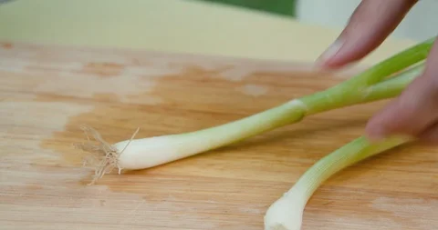 Woman's hands cleaning two spring onions Stock Footage 119845142