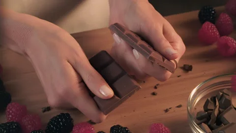 A woman’s hands in close up break up various size of chocolate bars Stock Footage 147513694