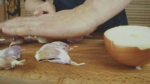 Woman's hands close up cutting onion and smashing, and peeling garlic on a Stock Footage 272796133