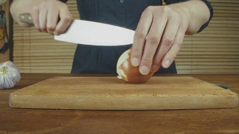 Woman's hands close up cutting onion and smashing, and peeling garlic on a Stock Footage 272799167