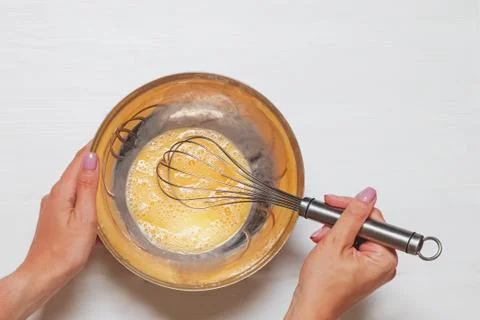 Woman's hands close-up mixing eggs and sugar with wisk in a bowl Stock Photos