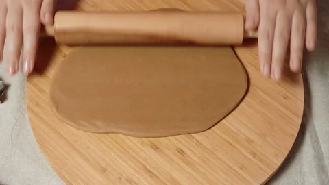 Woman's hands close-up roll out dough for gingerbread with a wooden rolling pin Stock Footage 143711773