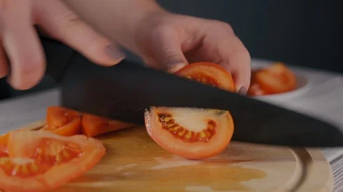 Woman's Hands Closeup Cut Ripe Tomato with Black Knife Stock Footage 103640480