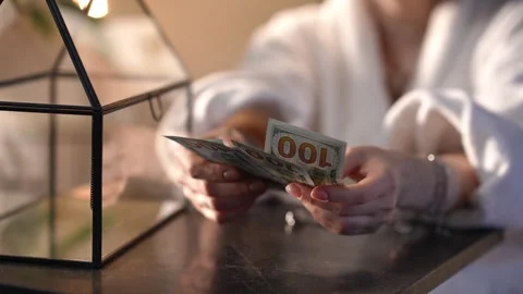 Woman's hands counting american one hundred dollar bills on a table Stock Footage 328006861