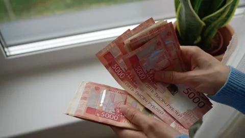 Woman's hands counting a large stack of russian ruble banknotes, close up view Stock Footage 344256763