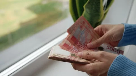 Woman's hands counting a large wad of 5000 russian ruble banknotes, calculating Vídeos de archivo 344289473
