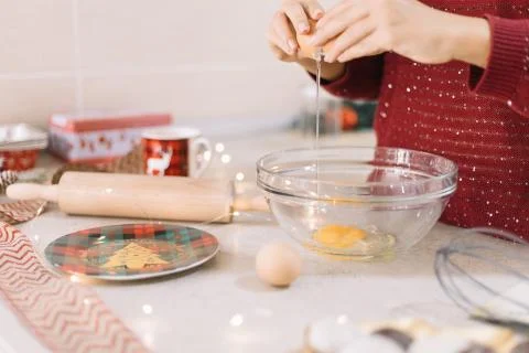 Woman's hands cracking eggs on kitchen bar Stock Photos