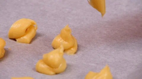 Woman's hands create profiteroles of choux pastry - close up Stock Footage 97976383