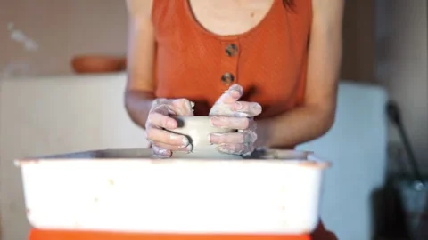 Woman's hands creating a clay bowl on a potter's wheel Stock Footage 277792920