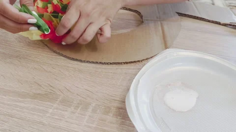 Woman's hands creating a DIY christmas wreath with paper flowers and cardboard 库存影片 341466133