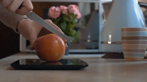 Womans hands cut the apple at pc tablet computer. Video stock 104826914