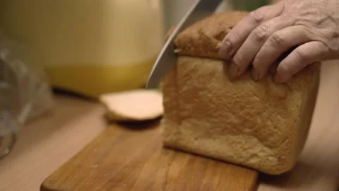 Woman's hands cut bread into thin pieces Stock Footage 130597422