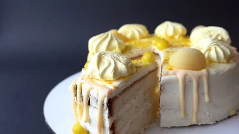 Woman's hands cut the cake with yellow cream on dark background. white cake Stock Footage 125360679