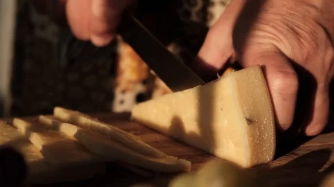 Woman's hands cut cheese on a cutting wooden board, slow motion Stock-Footage 113915360