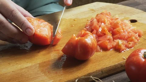 A woman's hands cut fresh tomatoes with a knife on a cutting board on a woo.. Stock Footage 332735217