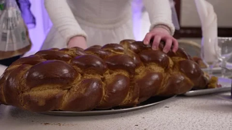 A woman's hands cut a large braided challah bread. This captures a cherishe.. Stock Footage 321029443