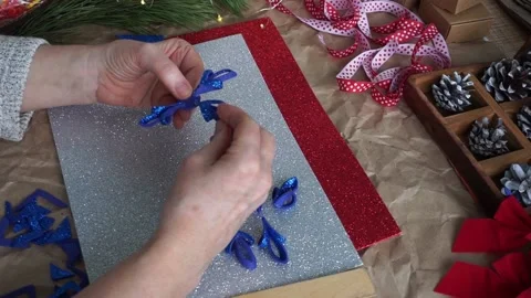 The woman's hands cut out the snowflake element from blue glitter foamiran, on Video stock 165377052